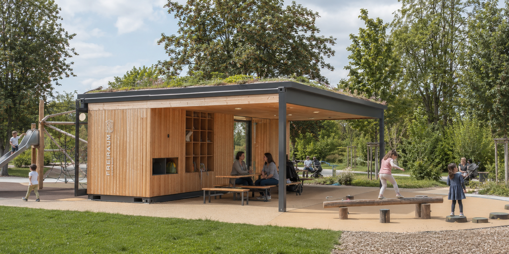Überdachtes Aufenthaltsgebäude in Modulbauweise mit begrüntem Dach und Holzfassade, davor eine Sitzgruppe und eine Spielfläche