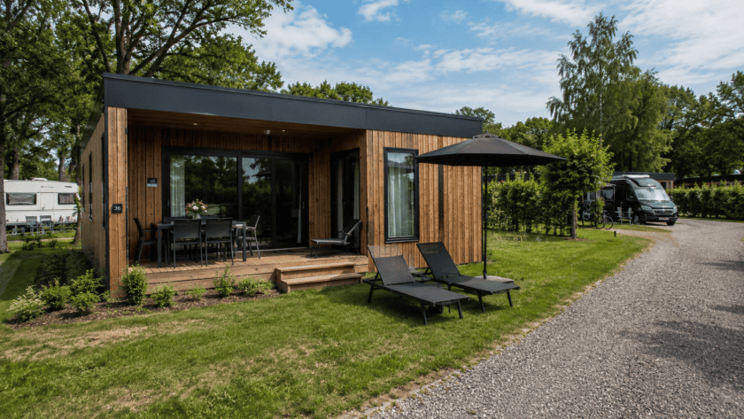 Ferienhaus in Modulbauweise mit Holzfassade, begrüntem Dach und überdachter Terrasse mit Liegen