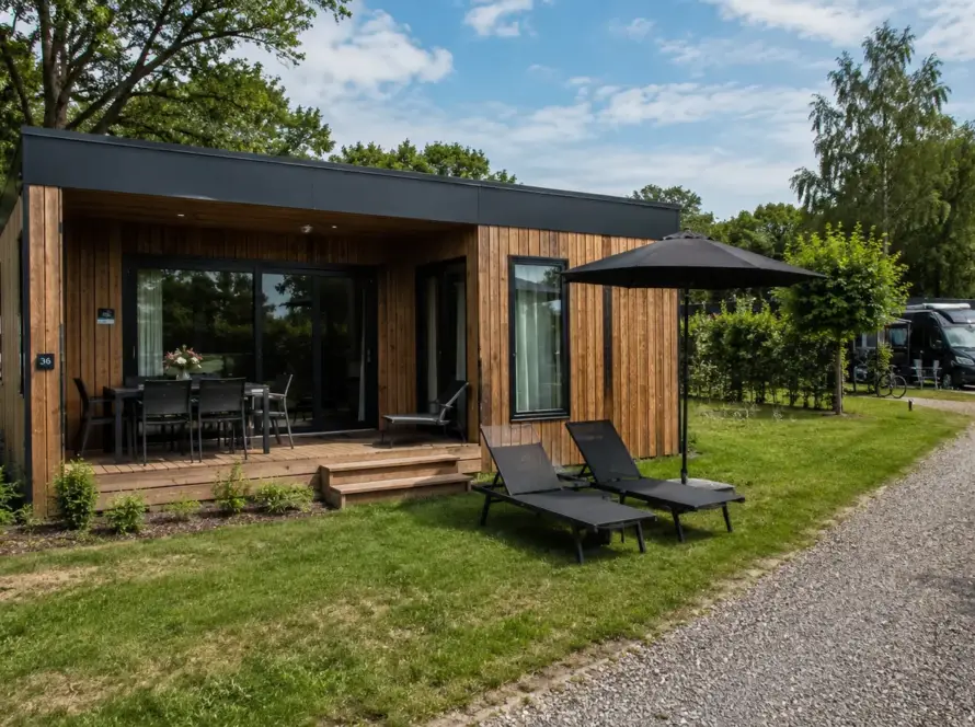 Ferienhaus in Modulbauweise mit Holzfassade, begrüntem Dach und überdachter Terrasse mit Liegen
