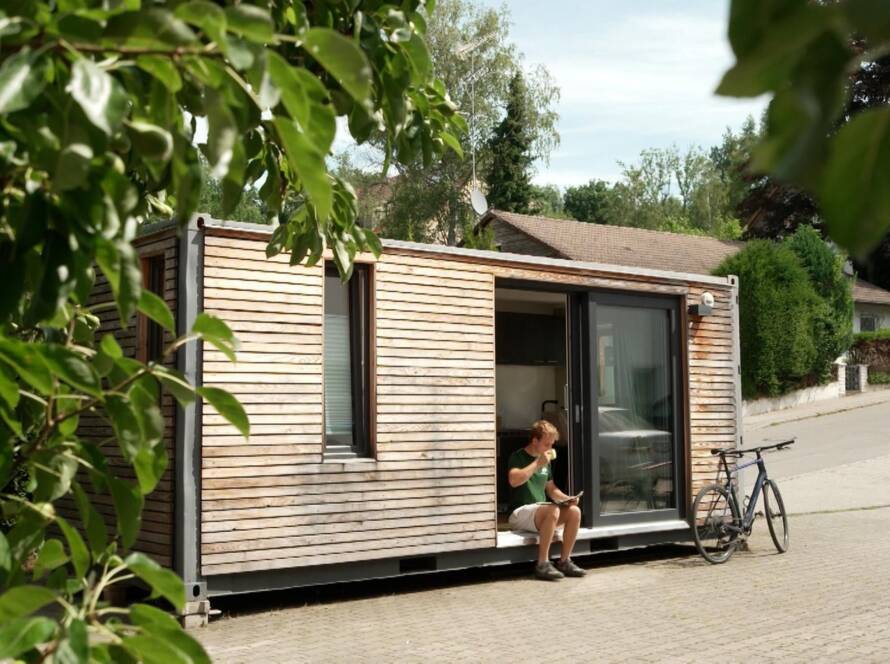 Tiny House von Contain-us aus einem Schiffscontainer, mit Holzverschalung und offener Schiebetür – Standbild aus dem BR-Beitrag der Abendschau