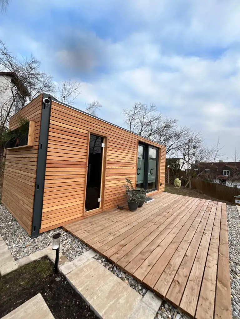 Fertiges Bürogebäude aus einem Raummodul mit Lärchenholzfassade, Glastür und vorgelagerter Holzterrasse