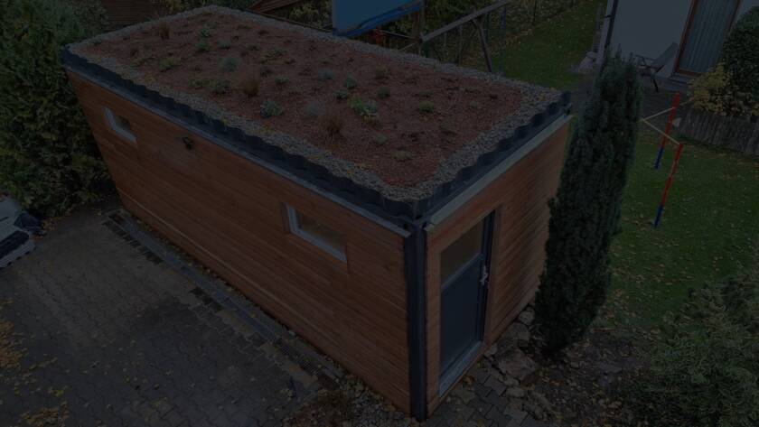 Gartenhaus 15 m² von Contain-us – Außenansicht mit begrüntem Dach auf einer gepflasterten Fläche