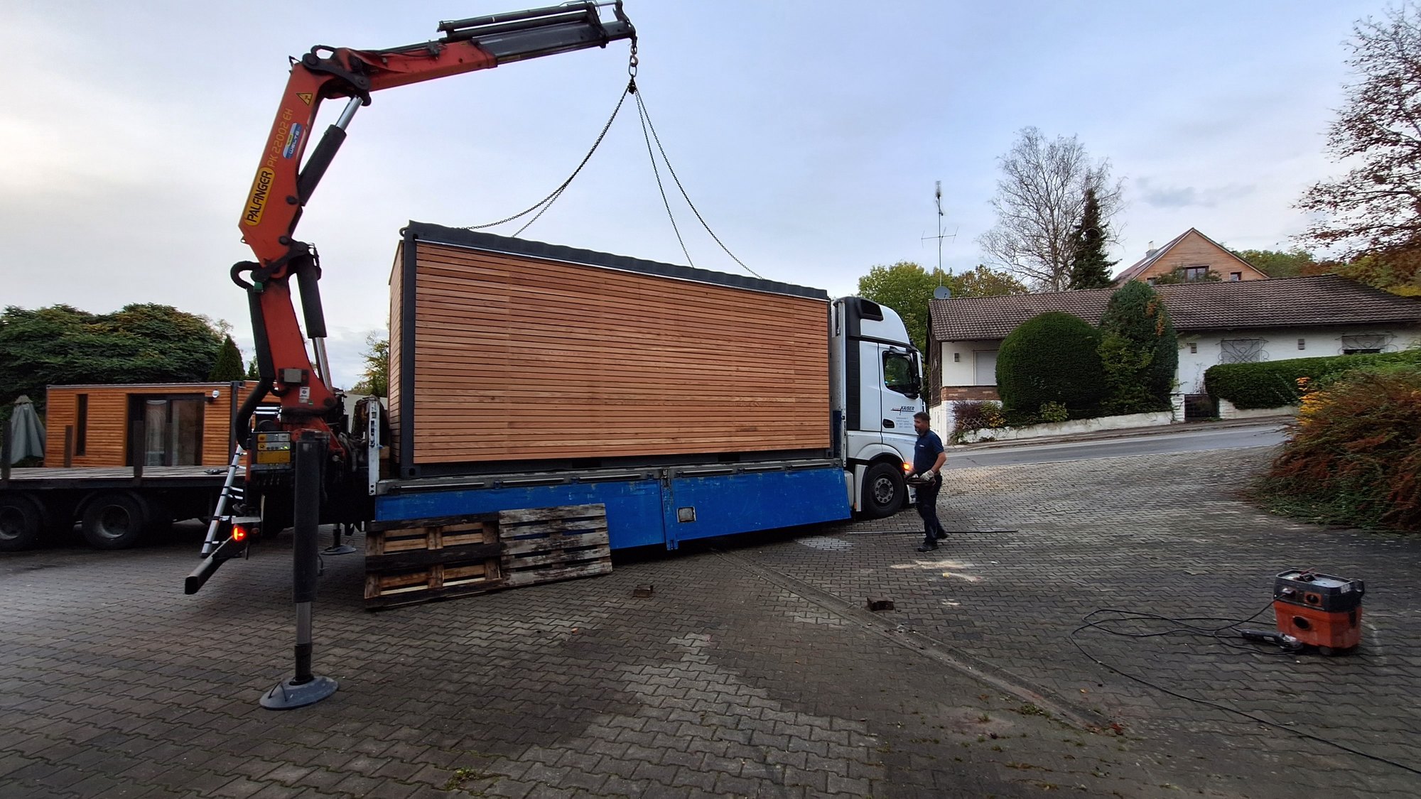 Gartenhaus mit Lärchenholzfassade auf dem Lkw vor der Aufstellung