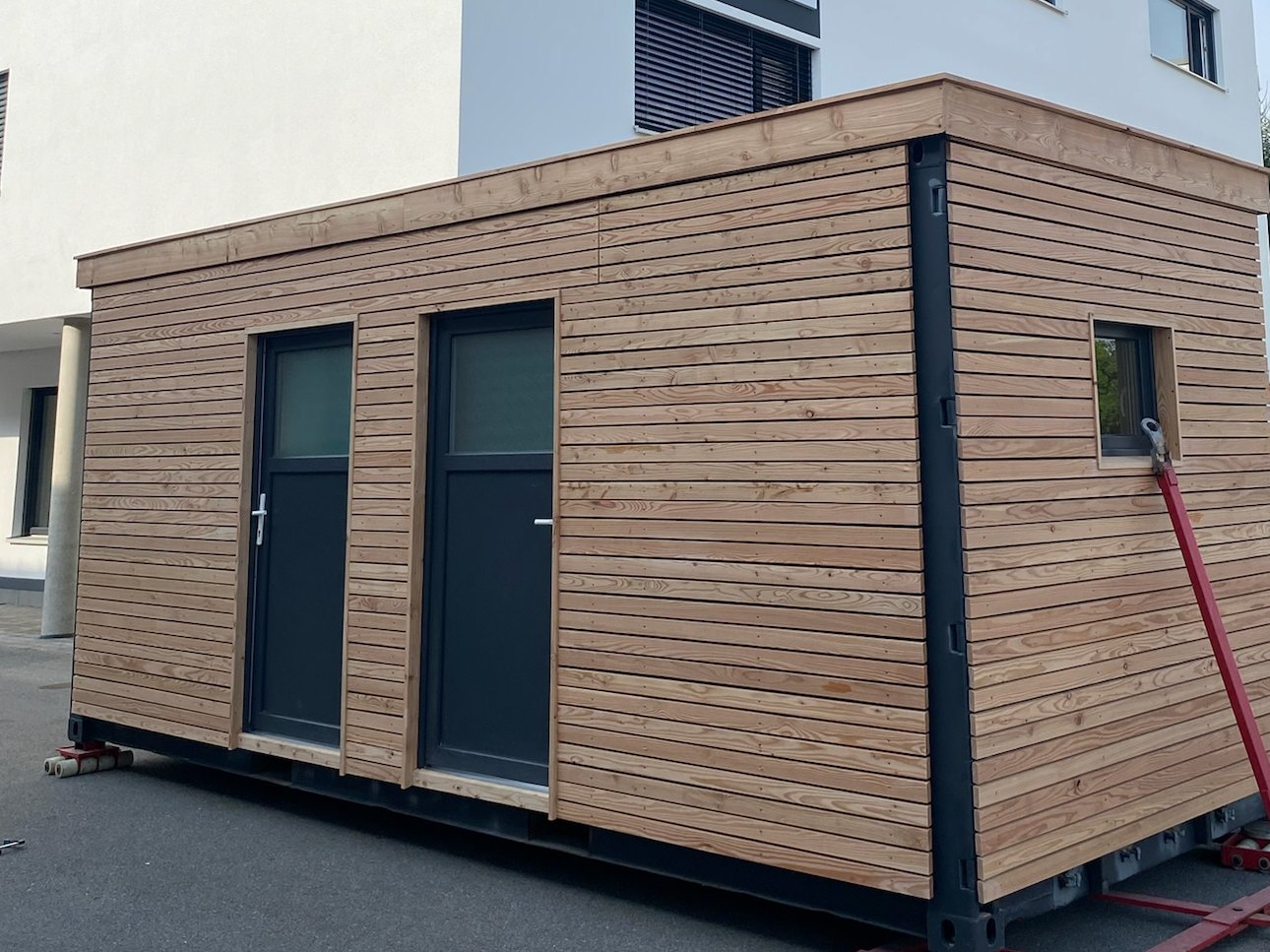 Gartenhaus 15 m² von Contain-us – das fertige Modul steht auf Rangierrollen und ist bereit für den Transport