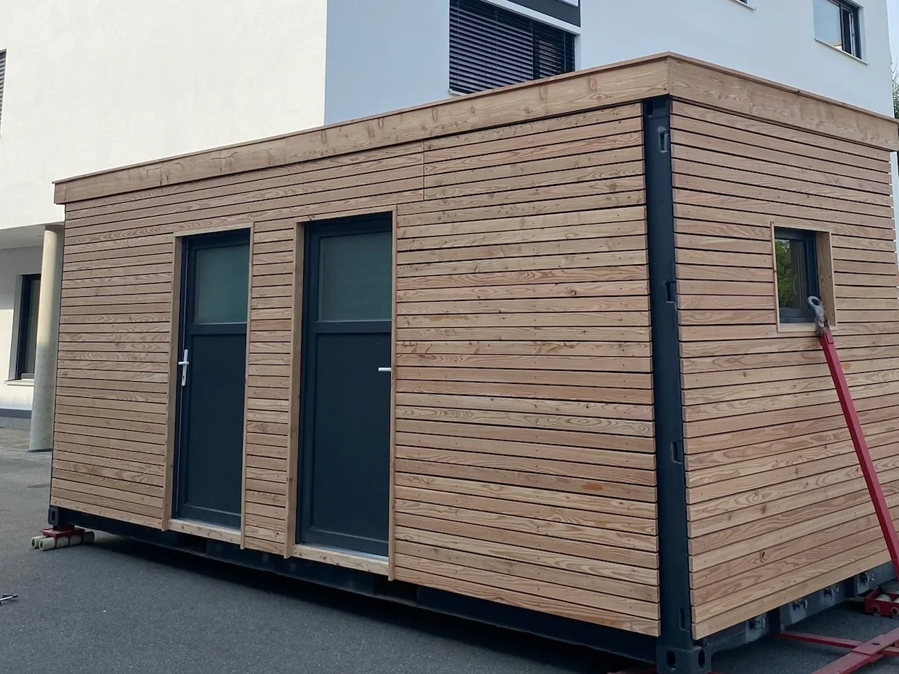 Gartenhaus 15 m² von Contain-us – das fertige Modul steht auf Rangierrollen und ist bereit für den Transport