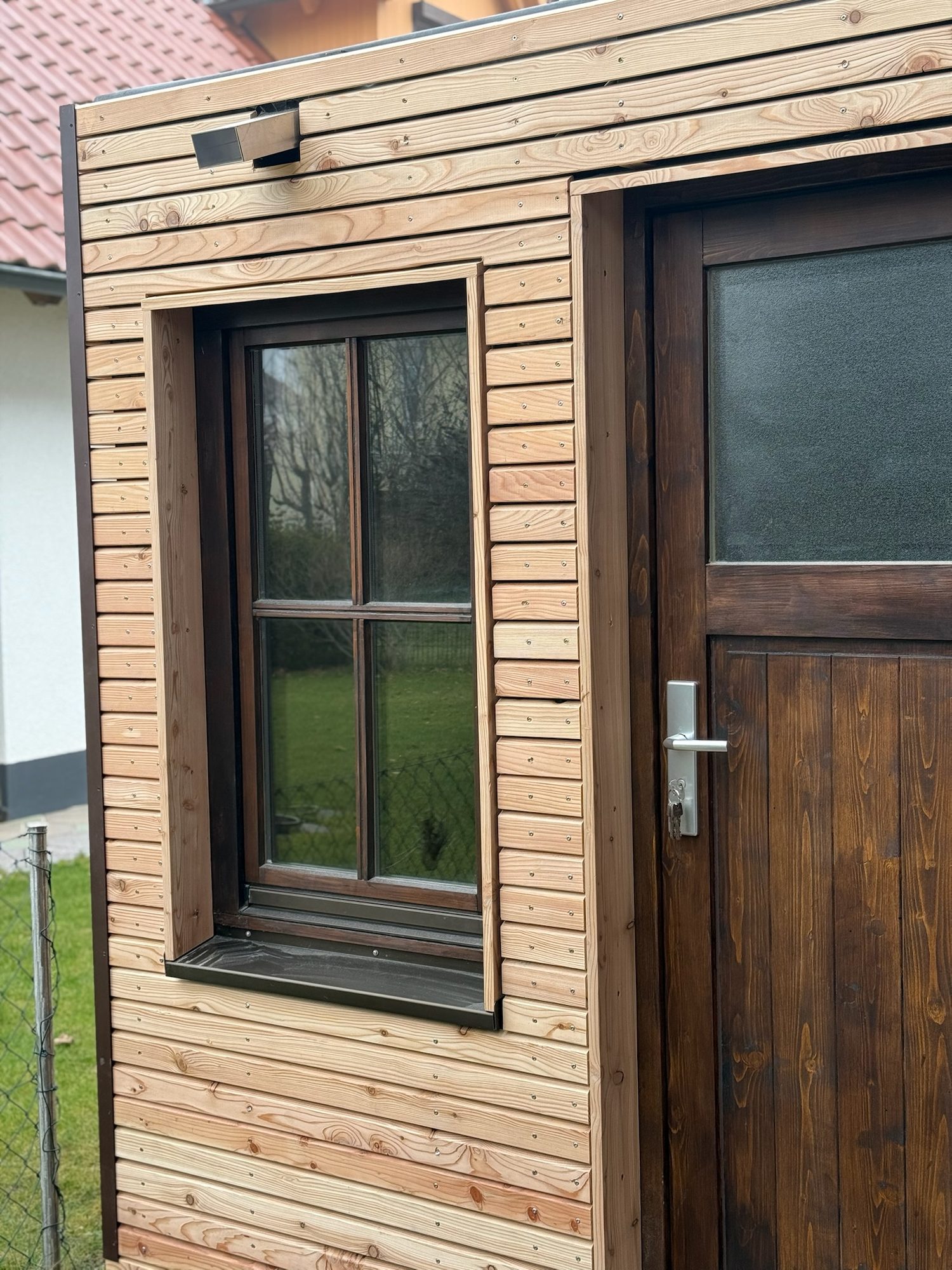 Gartenhaus 7 m² von Contain-us – Eingangstür mit Fenster in der hellen Holzfassade