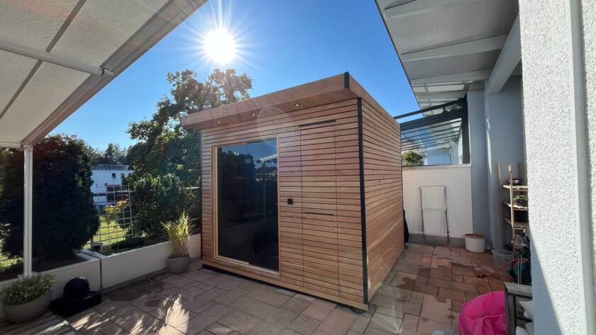 Sauna 7 m² von Contain-us – Außenansicht neben dem Wohnhaus, Glasfront zum Garten