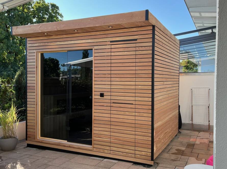 Sauna 7 m² von Contain-us – Außenansicht der freistehenden Gartensauna mit Panoramafenster und Holzfassade