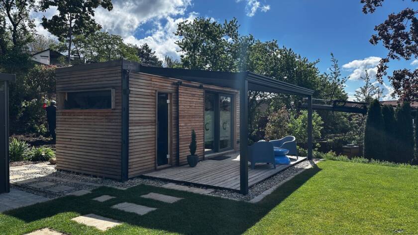 Sauna mit Büro 15 m² von Contain-us – Außenansicht mit Glasfront, davor eine gepflasterte Terrasse