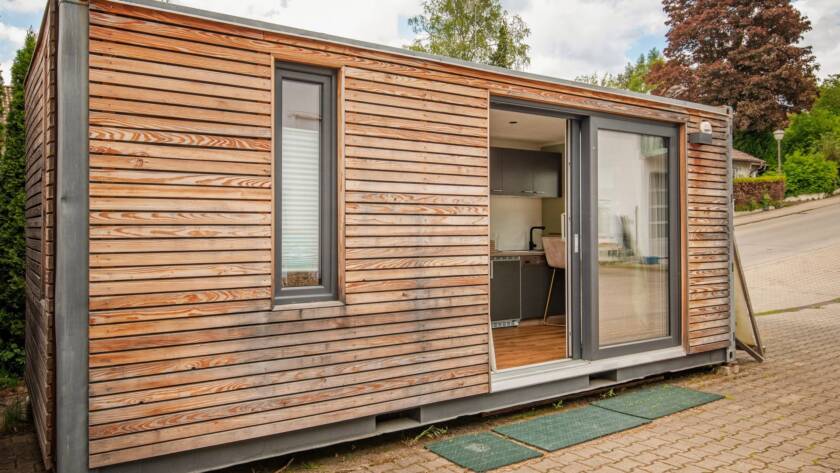Tiny House 15 m² von Contain-us – Außenansicht mit geöffneter Schiebefront, Blick in den Innenraum