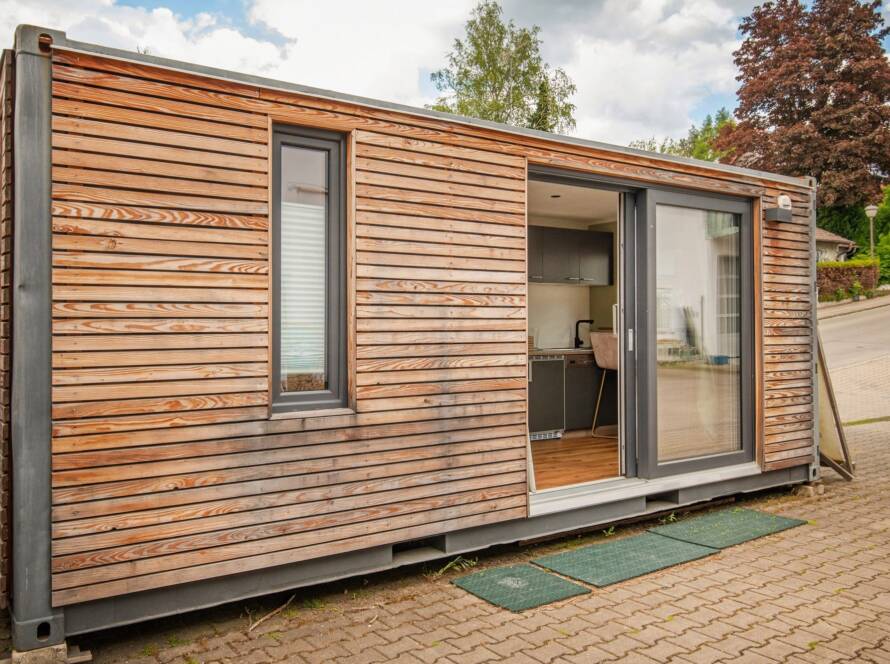 Tiny House 15 m² von Contain-us – Außenansicht mit geöffneter Schiebefront, Blick in den Innenraum