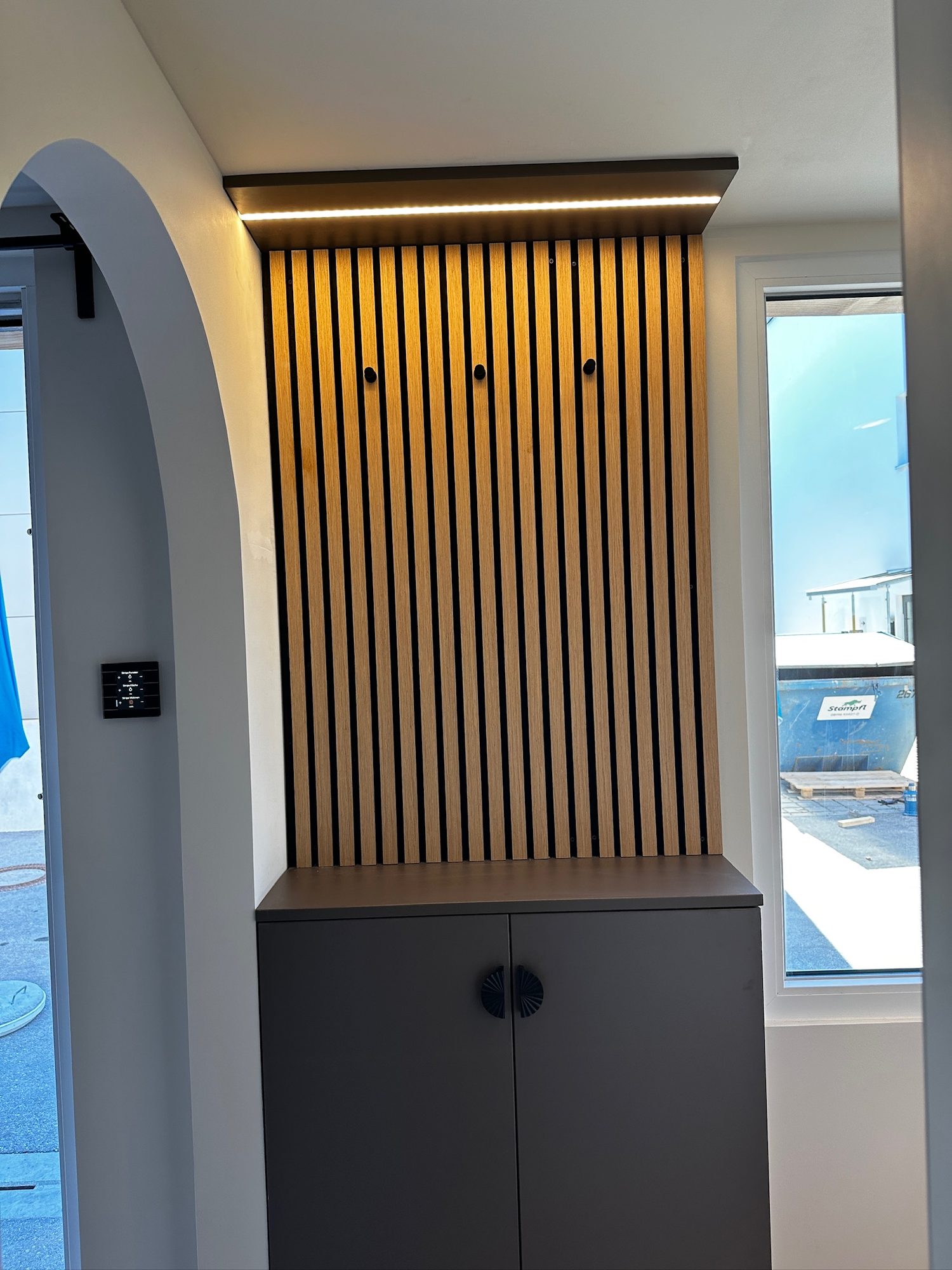 Tiny House 15 m² von Contain-us – Blick durch den Raum auf die Schlafnische hinter einer Holzlamellenwand