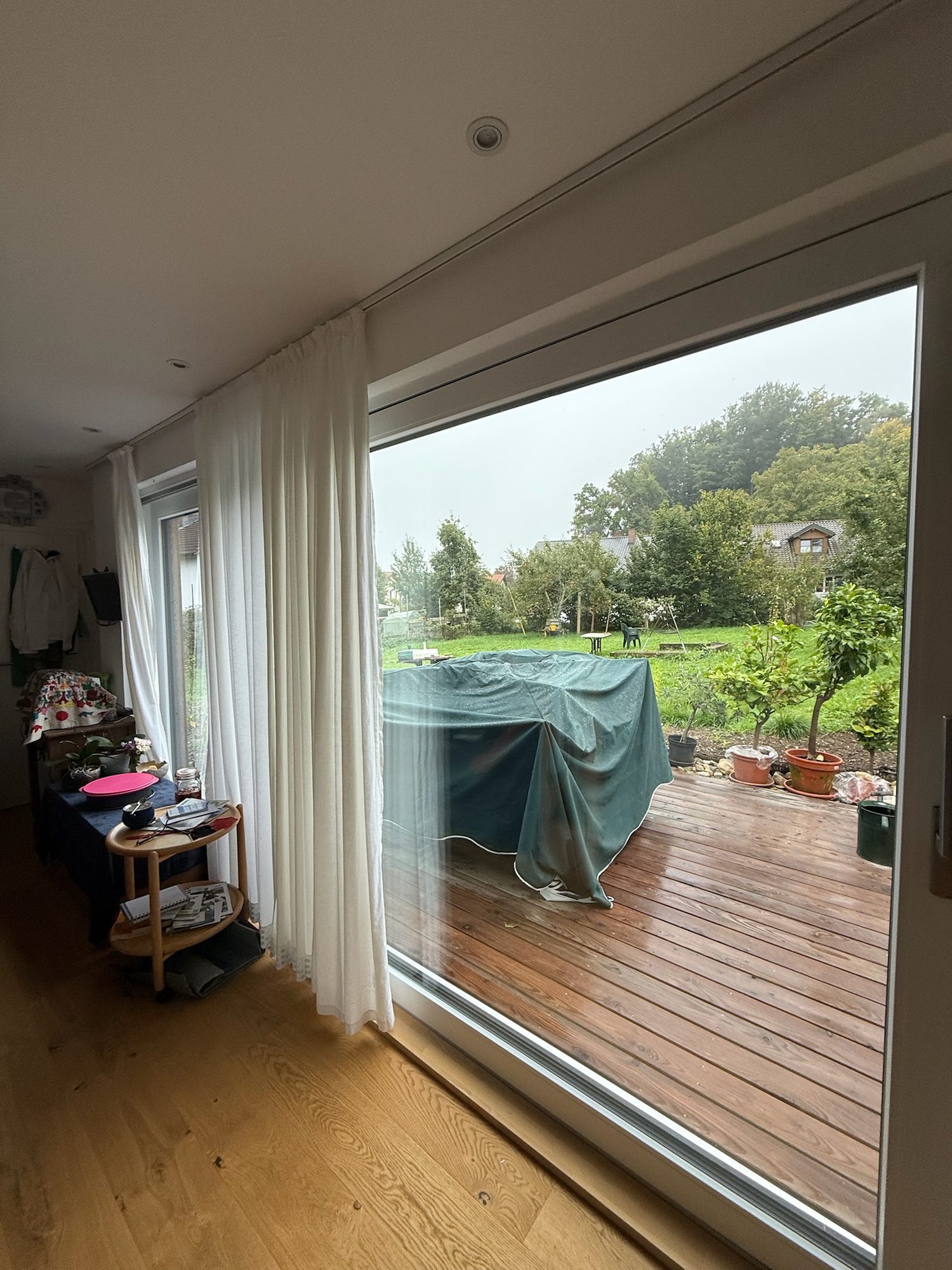 Tiny House 30 m² von Contain-us – Blick von innen durch die Schiebefront auf die Holzterrasse