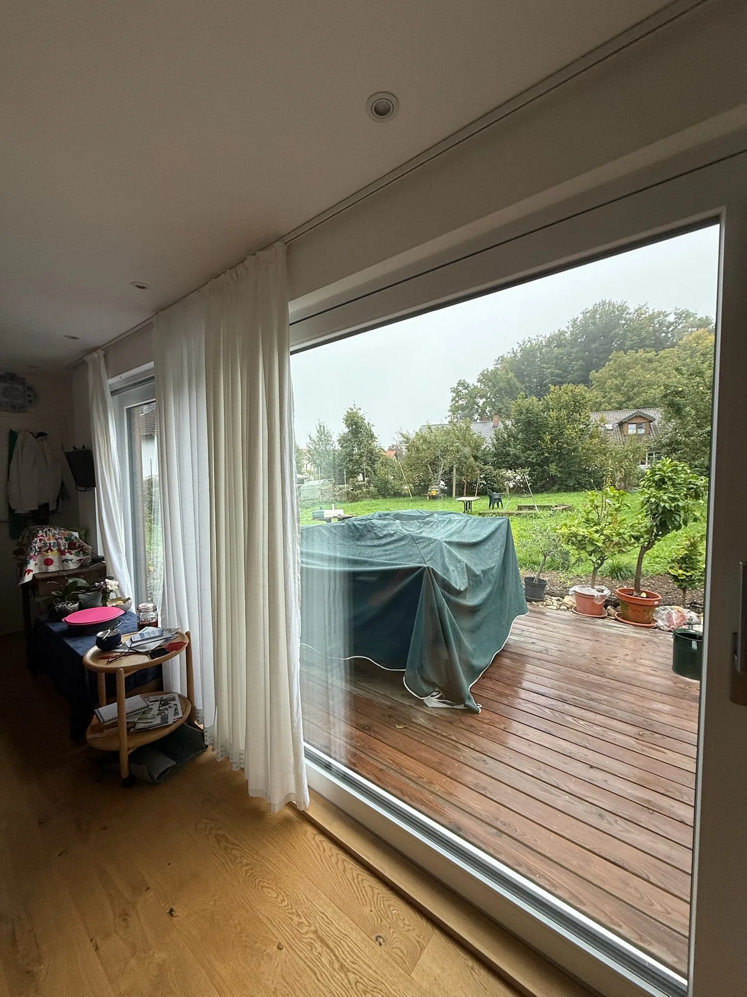 Tiny House 30 m² von Contain-us – Blick von innen durch die Schiebefront auf die Holzterrasse