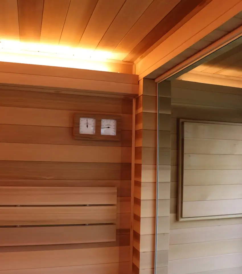 Sauna 7 m² von Contain-us – Blick von der Bank zur Glastür, Lichtband entlang der Deckenkante