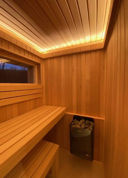 Sauna mit Büro 15 m² von Contain-us – Blick in den Saunaraum mit Bank, Fenster und Deckenlichtband
